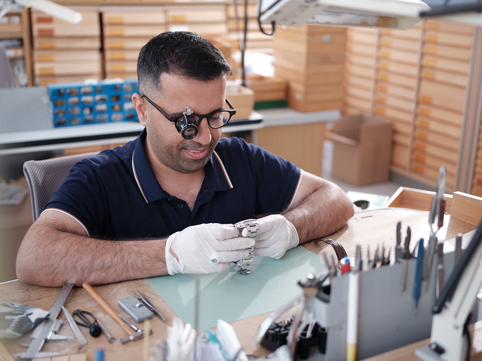 Uhrmacher mit Lupenbrille bei der Reparatur einer Armbanduhr in der Werkstatt von Engelkemper
